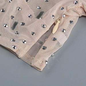 Detail of nude mesh fabric featuring silver rhinestones and a concealed teardrop zipper