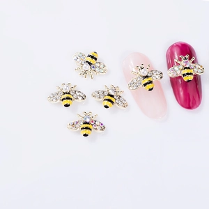 Detail of bee nail charms with gold alloy base and sparkling rhinestone inlay