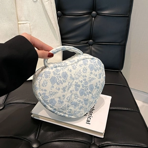 Close-up of heart-shaped quilted cotton makeup bag with blue floral pattern detail