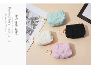 Close-up of four waffle texture coin purses with golden zippers and keyrings in pastel colors