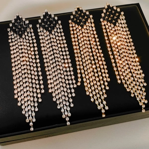 Close-up of geometric rhinestone tassel earrings in silver and gold luxury finishes