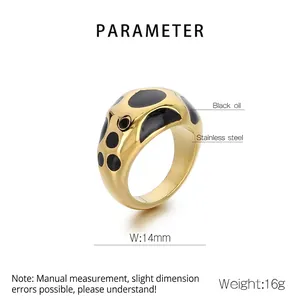 Macro detail of 14mm wide stainless steel ring with gold plating and black enamel dots
