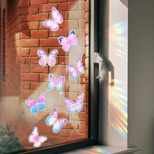 Holographic butterfly window stickers casting colorful rainbow light on a white wall