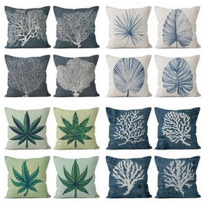 Macro detail of various linen pillow covers featuring coral and leaf patterns in grid layout
