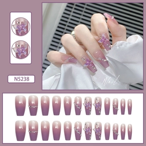 Detail view of purple gradient coffin nails with 3D butterflies and rhinestones decoration