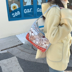 Close-up of cute cartoon bear print and blue piping on stylish canvas shoulder bag