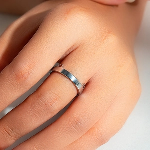 Silver cat ear ring on model's finger with a minimalist polished stainless steel finish