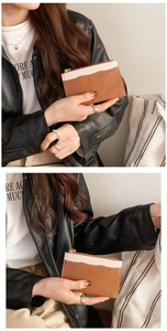Detail of the brown and white color-block leather coin purse with a gold zipper closure