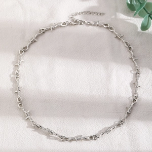 Macro detail of silver barbed wire heart necklace with adjustable extender chain