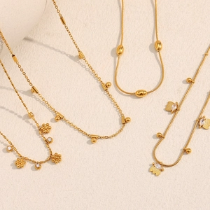 Détail de colliers en acier inoxydable plaqué or 18K avec pendentifs fleur et papillon