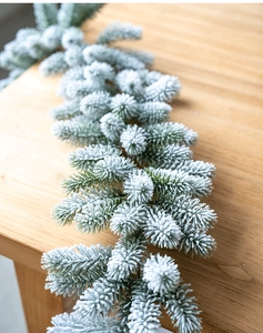 Vue macro d'une guirlande de pin floquée réaliste avec revêtement de neige sur table en bois
