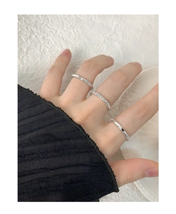 Detailed view of silver rings featuring Lucky engraving, heart and smiley face symbols