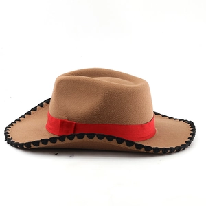 Detail of brown felt cowboy hat with red ribbon trim and black stitched brim edge
