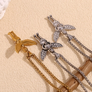 Detailed view of angel wing pendants in gold and silver finish with sparkling rhinestones