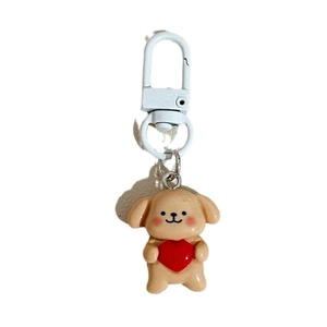Simpatico portachiavi a forma di cane beige con cuore rosso su sfondo bianco