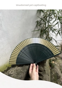 Detailed macro view of a vintage Chinese folding fan with bamboo frame and metal chain