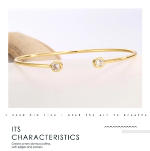 Detailed macro view showing the mirror finish and zircon inlay on a gold open cuff bracelet