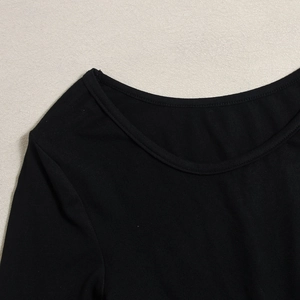 Gros plan du décolleté en tricot noir montrant la texture et la qualité du tissu