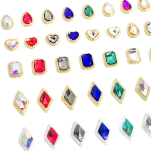 Amuletos para uñas con gemas y bordes metálicos en formas de gota, corazón y rombo