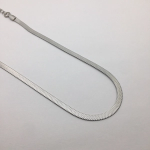 Macro view of a silver flat snake blade chain in titanium steel on white background