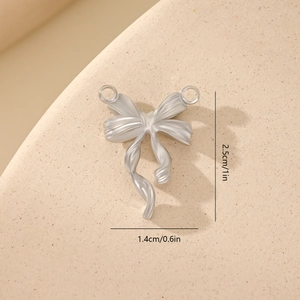 Macro detail of silver bow pendant with dimensions 2.5cm by 1.4cm for jewelry making