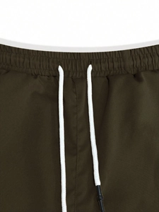 Detail of olive green cargo pants featuring elastic drawstring waist and twill fabric texture