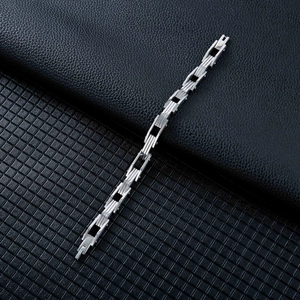 Dettaglio macro del bracciale a maglie geometriche argento con design industriale e chiusura