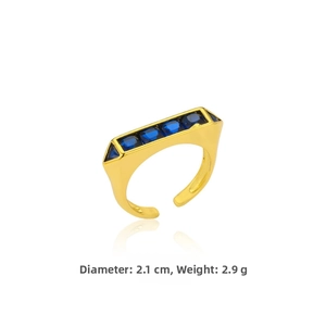 Gros plan bague géométrique dorée pierres bleues montrant diamètre 2,1cm et poids de 2,9g