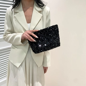 Fashionable black sequin clutch bag for women paired with elegant beige suit
