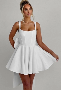 Close-up of white mini dress with corset bodice and large back bow detail
