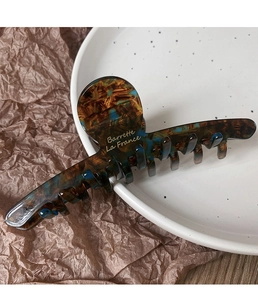 Dettaglio molletta per capelli in acetato tartarugato con scritta oro Barrette La France