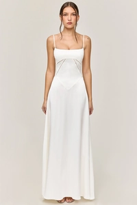 Front view of a white satin slip maxi dress with thin straps and geometric waist seams