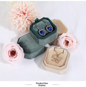Close-up of elegant octagonal velvet jewelry box with sapphire heart earrings inside