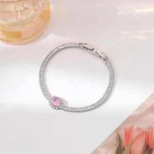 Macro detail of silver bracelet with pink oval stone and square zirconia stones