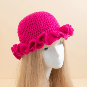 Detail of handmade crochet knit fisherman hat with ruffle brim in vibrant rose red