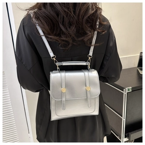 Détail du sac à dos en cuir PU argenté avec boutons dorés et poignée supérieure