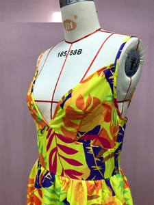 Detail view of tropical leaf print and deep V-neckline on yellow bohemian maxi dress