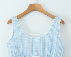 Detailed view of blue gingham dress bodice featuring white lace trim and front buttons