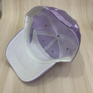 Detail of purple sequin baseball cap interior showing white cotton lining and size tag