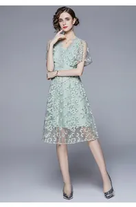 Details der hellgrünen Spitzenstickerei und Blumenmuster auf dem französischen V-Ausschnitt-Kleid