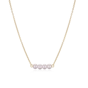 Close-up of four round pearls on a golden metal chain for an elegant minimalist look