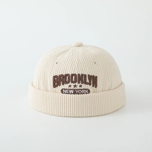 Detailed texture of beige corduroy docker hat with Brooklyn New York star embroidery