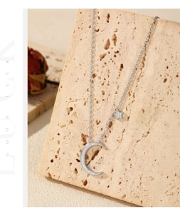 Detail of silver S925 moon and star pendant necklace on a decorative stone base