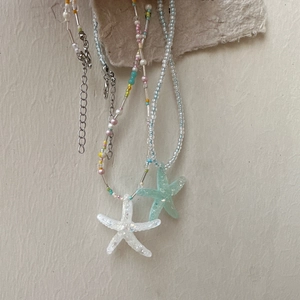 Detail of colorful starfish pendant beaded necklace with adjustable metal chain
