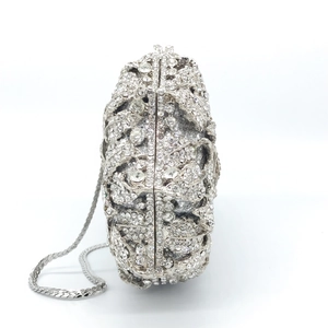 Detail of silver rose-shaped evening clutch bag with luxury rhinestones and metal chain