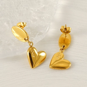 Macro detail of gold-plated stainless steel heart earrings with LOVE engraving