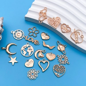 Flat lay of gold hollow heart and celestial charms on blue background for DIY jewelry