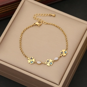 Detail von goldenem Kleeblatt Armband mit blauem Auge und Kristallen auf Schmuckkästchen