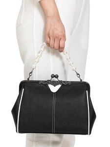 Detail of black handbag with white piping trim and pearl beaded handle featuring metal clasp