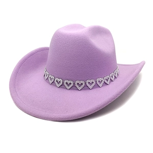 Détail d'un chapeau de cowboy lavande avec bandeau décoratif en métal à motifs cœurs